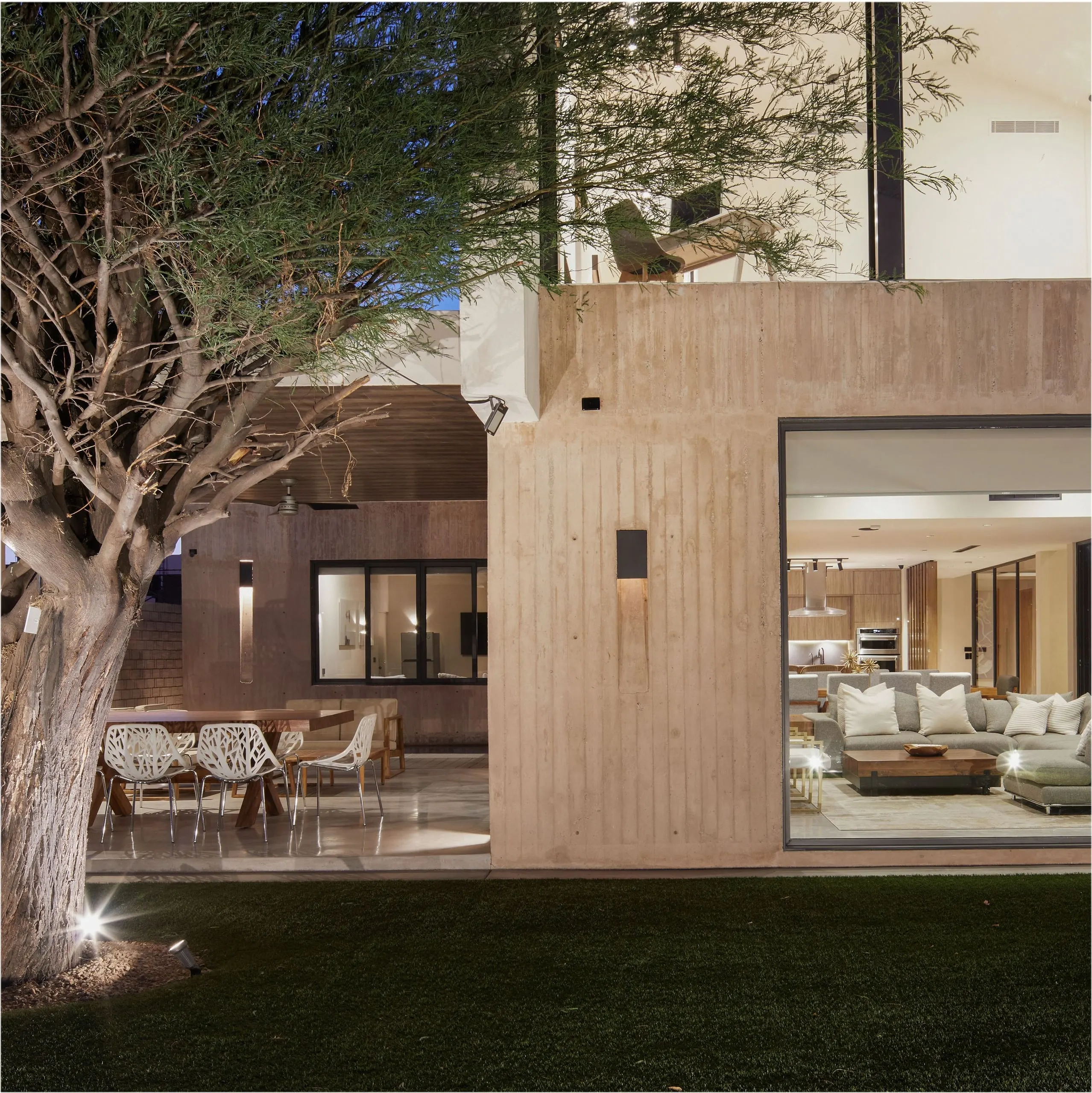 Casa Edena: terraza y sala abiertas al jardín al anochecer
